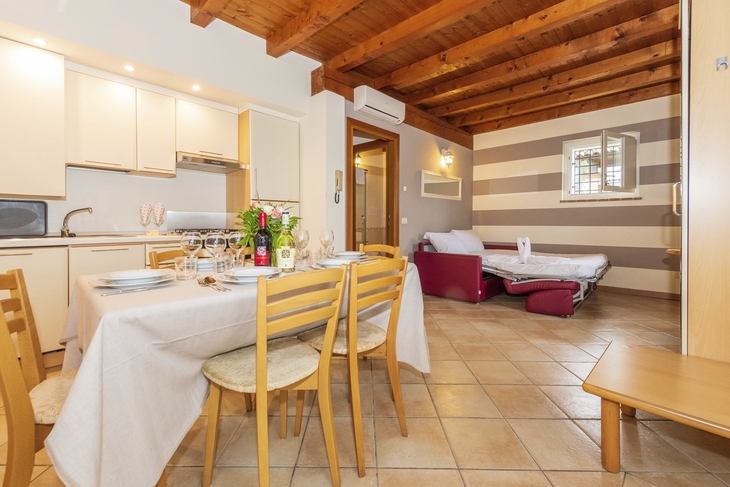 Essbereich und Wohnzimmer einer Ferienwohnung mit Holzbalkendecke.