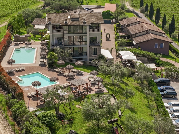 Luftaufnahme von Ferienwohnungen mit Pool und grüner Anlage in Peschiera del Garda.