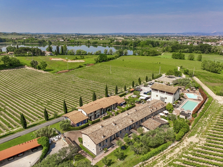 Luftaufnahme von La Bertoletta Village mit Pool und umliegenden Weinbergen.