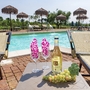 Liegestühle am Pool mit Weinflasche und Weintrauben im Vordergrund.