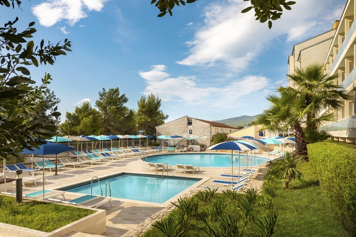 Außenpool mit Liegestühlen und Sonnenschirmen im Rabac Sunny Hotel & Residence.