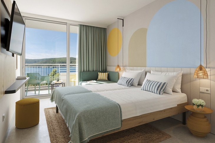 Hotelzimmer mit Doppelbett, modernem Dekor und Balkon mit Meerblick.