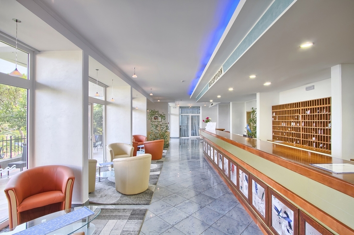 Hotel-Lobby mit Rezeption, Sitzgelegenheiten und modernem Design.