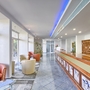 Hotel-Lobby mit Rezeption, Sitzgelegenheiten und modernem Design.