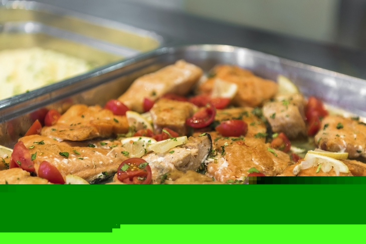 Gebackener Lachs mit Zitronen und Tomaten im Restaurantbuffet.