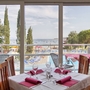 Blick aus einem Hotelrestaurant auf Terrasse und Meer mit gedecktem Tisch.
