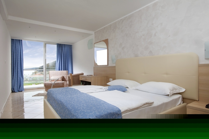 Hotelzimmer mit Doppelbett, Balkon und Meerblick in Rabac, Kroatien.