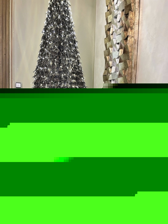 Weihnachtlich geschmücktes Zimmer mit glitzerndem Baum und Rentierfiguren.