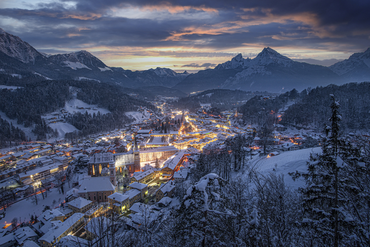 Winterliches Panorama von Berchtesgaden bei Sonnenuntergang mit verschneiten Bergen.