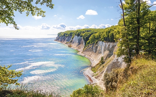 Kreideküste Rügens mit blauem Meer und grünem Wald.