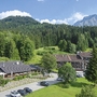 Alpenresidenz in Berchtesgaden umgeben von Bäumen und Bergen im Sommer.