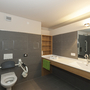 Barrierefreies Badezimmer mit Haltegriffen und breitem Waschbecken.