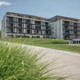 Modernes Resortgebäude in St. Kanzian am Klopeiner See, umgeben von Grünflächen.