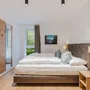 Helles Hotelzimmer mit Doppelbett und moderner Einrichtung.