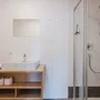 Modernes Badezimmer mit Waschbecken, Spiegel und Dusche.