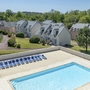Ferienresort mit Pool, umgeben von grüner Landschaft und mehreren Gebäuden.