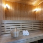 Sauna mit Holzwänden, Bank, Eimer und zwei Handtüchern.