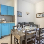 Küchenbereich mit Esstisch, blauen Schränken und Sofa.