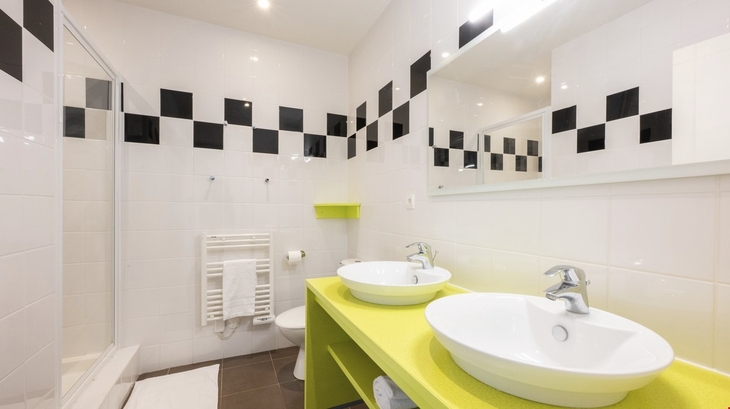 Badezimmer mit zwei Waschbecken, Dusche und modernem Design.