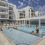 Außenpool eines modernen Apartmentkomplexes mit Menschen beim Schwimmen.