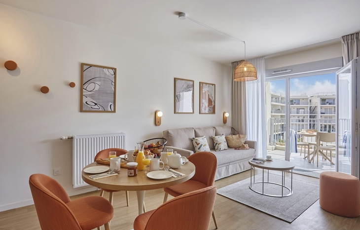 Moderne Wohnzimmereinrichtung mit Esstisch, Sofa und Balkonblick.