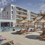 Ein moderner Apartmentkomplex mit einem Außenpool und Sonnenliegen.
