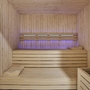 Sauna mit Holzwänden und zwei Liegeflächen.