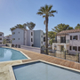 Außenansicht von Ferienunterkünften mit Pool und Palmen im Odalys Résidence Prestige La Riviera.