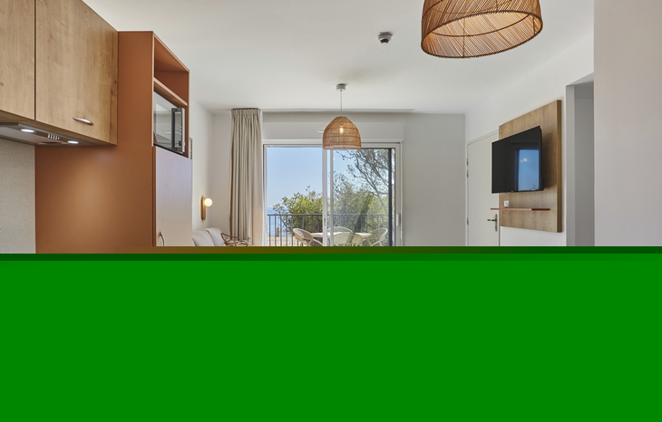 Moderne Ferienwohnung mit Essecke und Blick auf Terrasse.