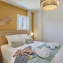 Modernes Schlafzimmer mit Doppelbett, Fenster und dekorativen Lampen.