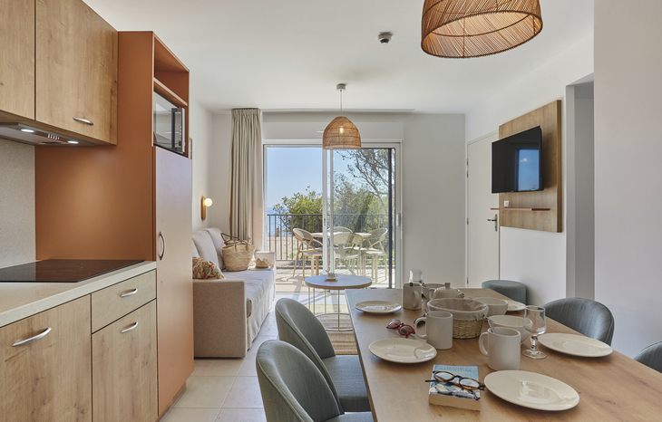 Moderne Ferienwohnung mit Essecke und Blick auf Terrasse.