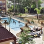 Poolbereich mit Sonnenschirmen und Menschen bei Odalys Résidence Prestige Les Canissons.
