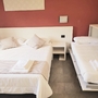 Doppelbett und ausklappbares Bett in modernem Schlafzimmer mit roter Wand