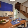 Essbereich mit Holztisch, Treppe und Küchenzeile in Ferienwohnung.