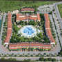 Luftaufnahme eines Ferienresorts mit Pool im Zentrum und roten Dächern in Bibione.