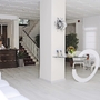 Helle Hotel-Lobby mit Rezeption, Pflanzen und Sitzbereich.