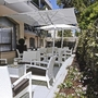 Terrasse eines Hotels mit weißen Sitzmöbeln und Sonnenschirmen