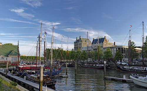 Schiffe im Hafen nahe der Erasmusbrücke in Rotterdam bei klarem Himmel.