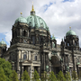 Berliner Dom mit Fernsehturm im Hintergrund bei bewölktem Himmel