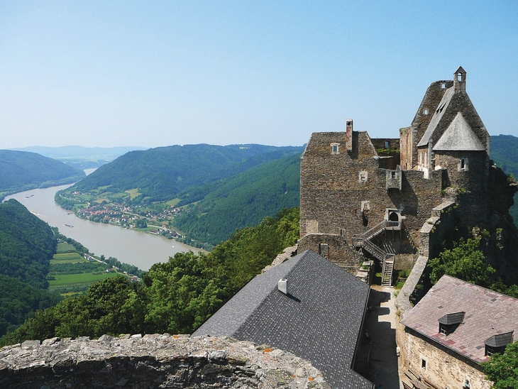 Burgruine Aggstein mit Blick auf die Donau und umliegende Hügel bei klarem Himmel.