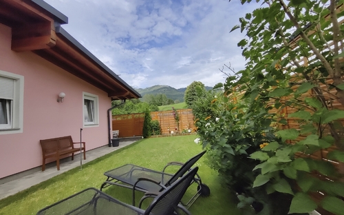 Garten eines Bungalows mit Liegestühlen und Bergblick in Bad Ischl.