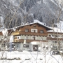 Ein von Schnee bedecktes Hotel im Winter in einer bergigen Landschaft.