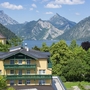 Landhotel Post Ebensee vor Bergkulisse und See im Salzkammergut.