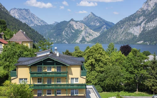 Landhotel Post Ebensee vor Bergkulisse und See im Salzkammergut.