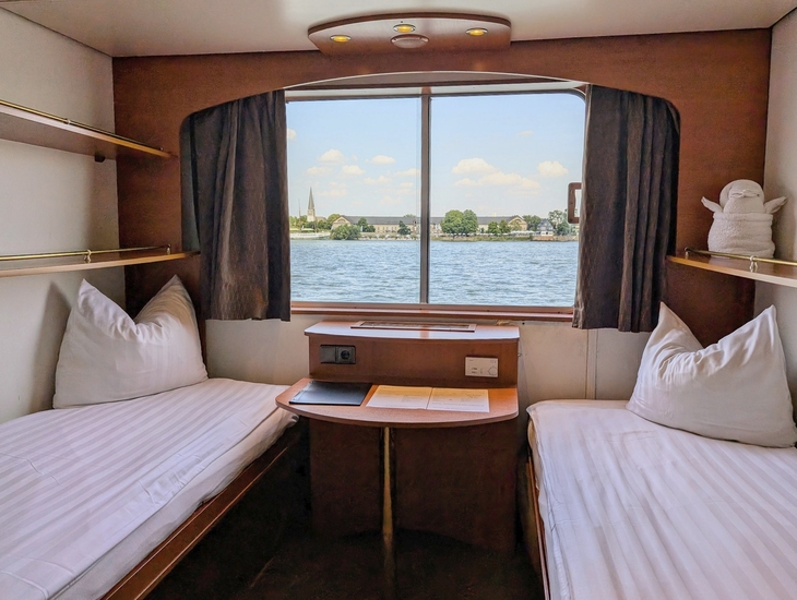 Zweibettkabine auf Schiff mit Fensterblick aufs Wasser
