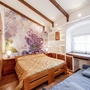 Helles Schlafzimmer mit Holzmöbeln und Blumendekoration an der Wand.