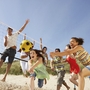 Menschen spielen Beachvolleyball am sonnigen Strand.