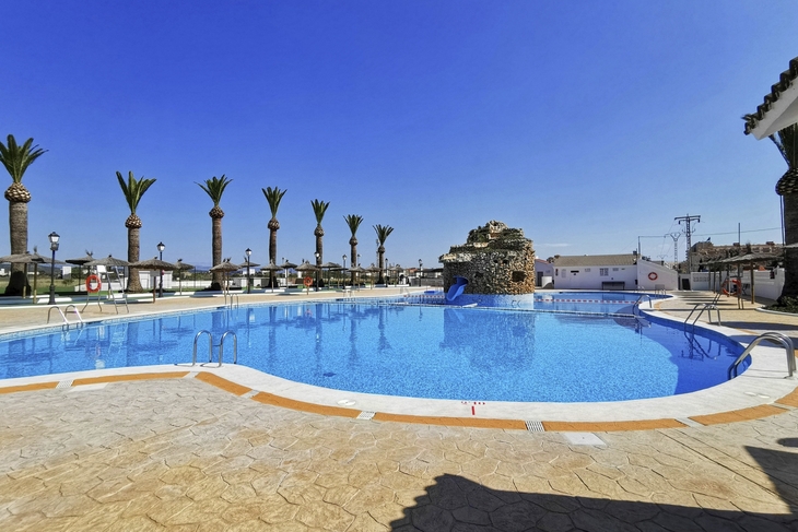 Außenpool mit Palmen und Wasserfall im Acualandia Aparthotel in Peñíscola.