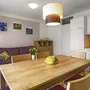 Moderne Ferienwohnung mit Essbereich, Wohnbereich und Küche in Holzoptik.