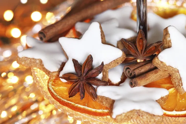 Weihnachtsgebäck und Gewürze vor Lichterhintergrund